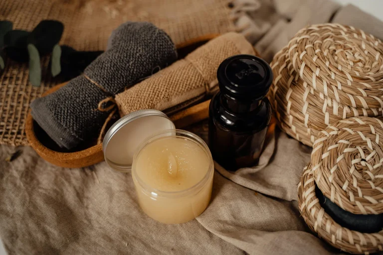 Spa essentials for Thai massage: rolled towels, body butter, oil in a dark glass bottle and woven baskets